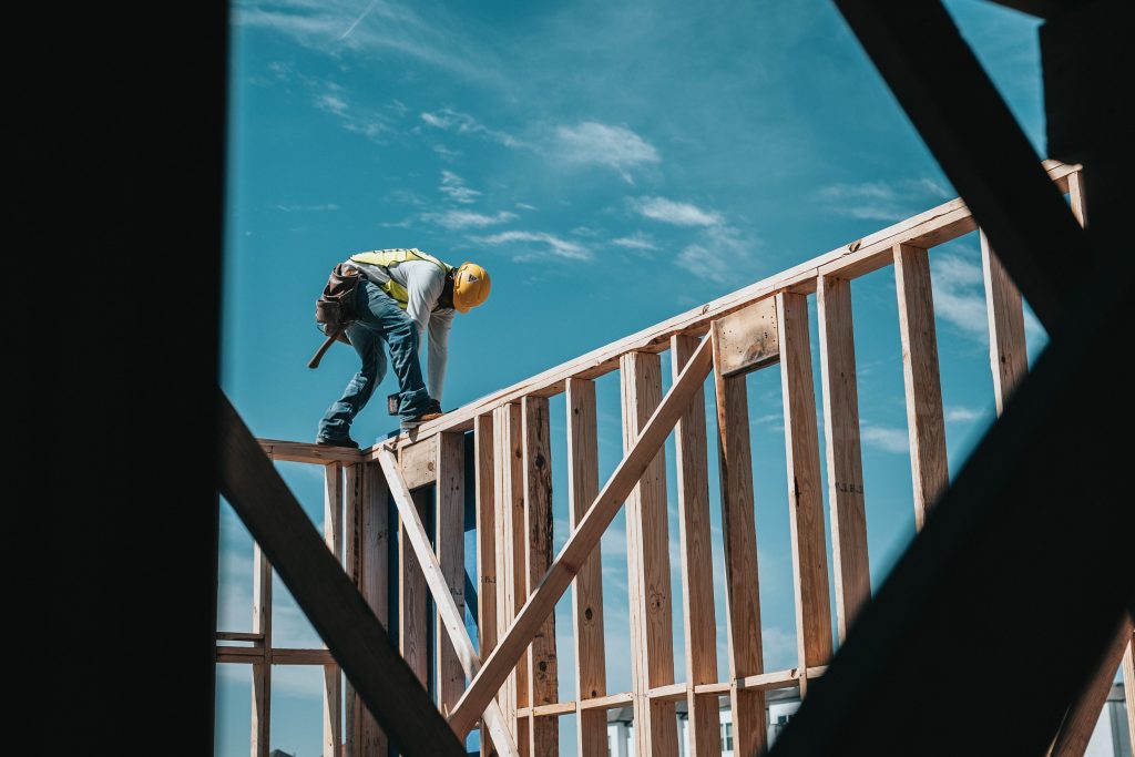 A construction professional works on a building frame.
